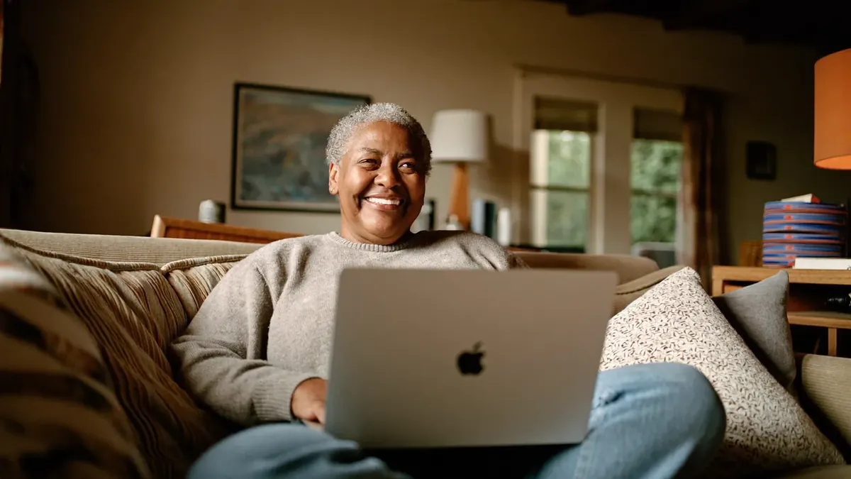 A woman in her forties browsing the Colorado health insurance marketplace on a laptop at home