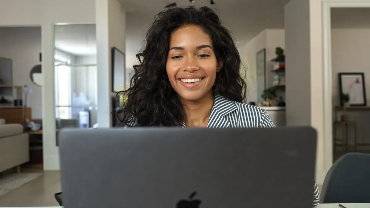 A woman in her forties browsing the Colorado health insurance marketplace on a laptop at home