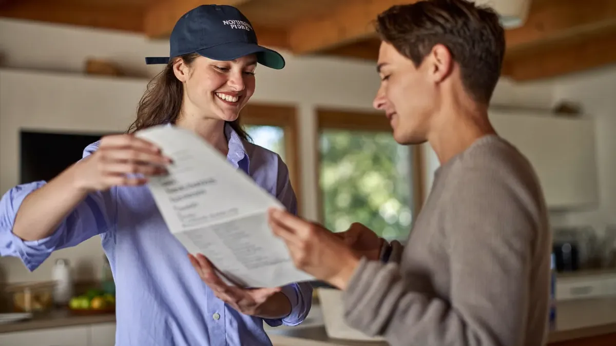 A friendly young insurance advisor helping an adult client choose a health plan in a sunny Colorado office