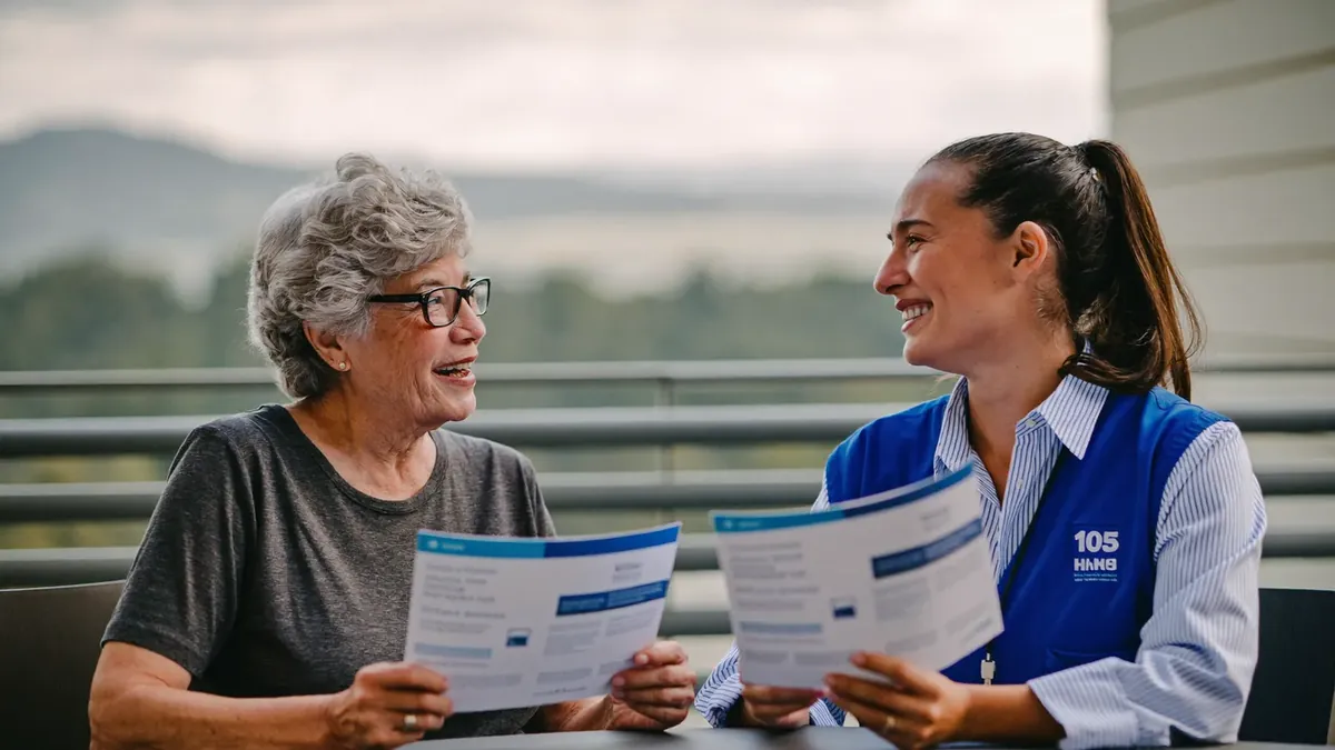 A smiling senior couple meeting a young insurance agent in a bright Broomfield office, reviewing Medicare supplement brochures