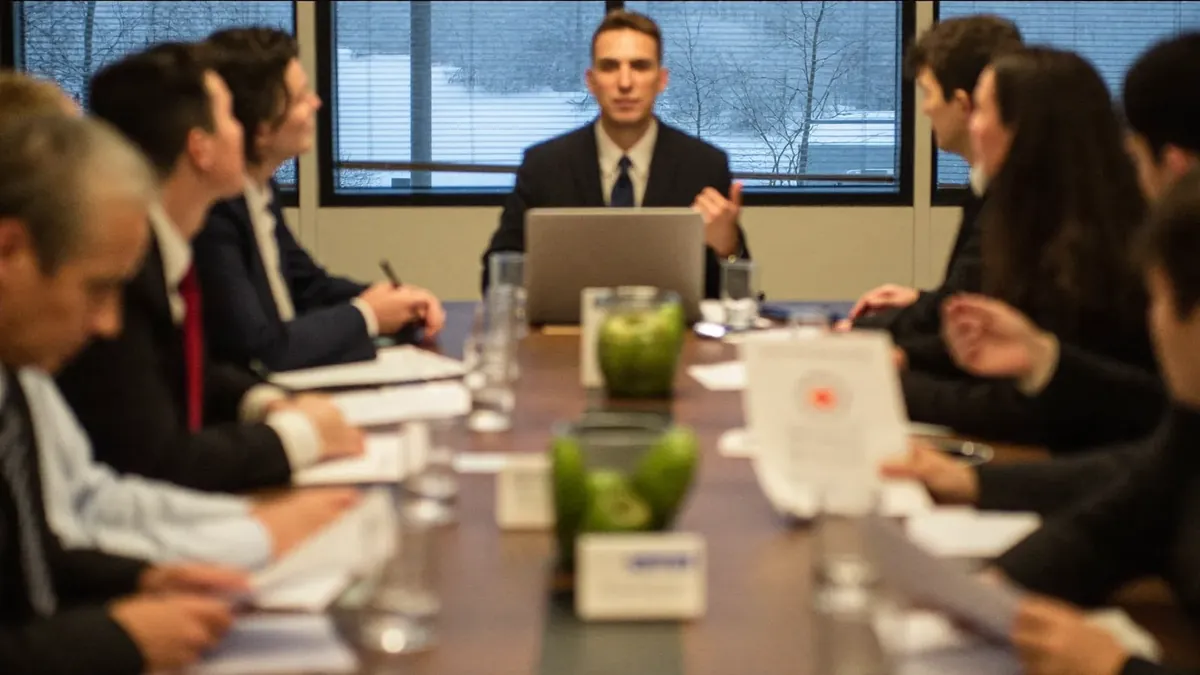 A small Colorado business team gathered around a conference table while an insurance advisor presents benefits options